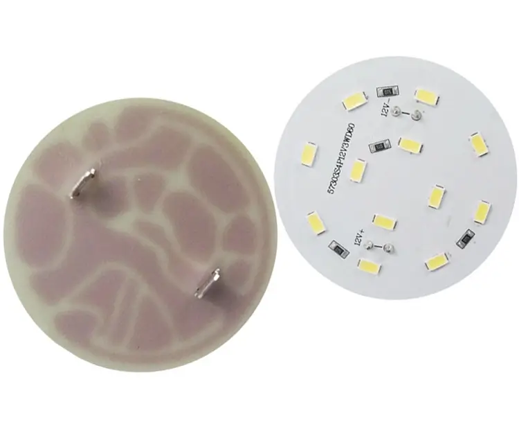 Two circular printed circuit boards (PCBs). On the left is a PCB with a marbled brown and tan pattern, and on the right is a white PCB with multiple LED components arranged in a circular pattern.